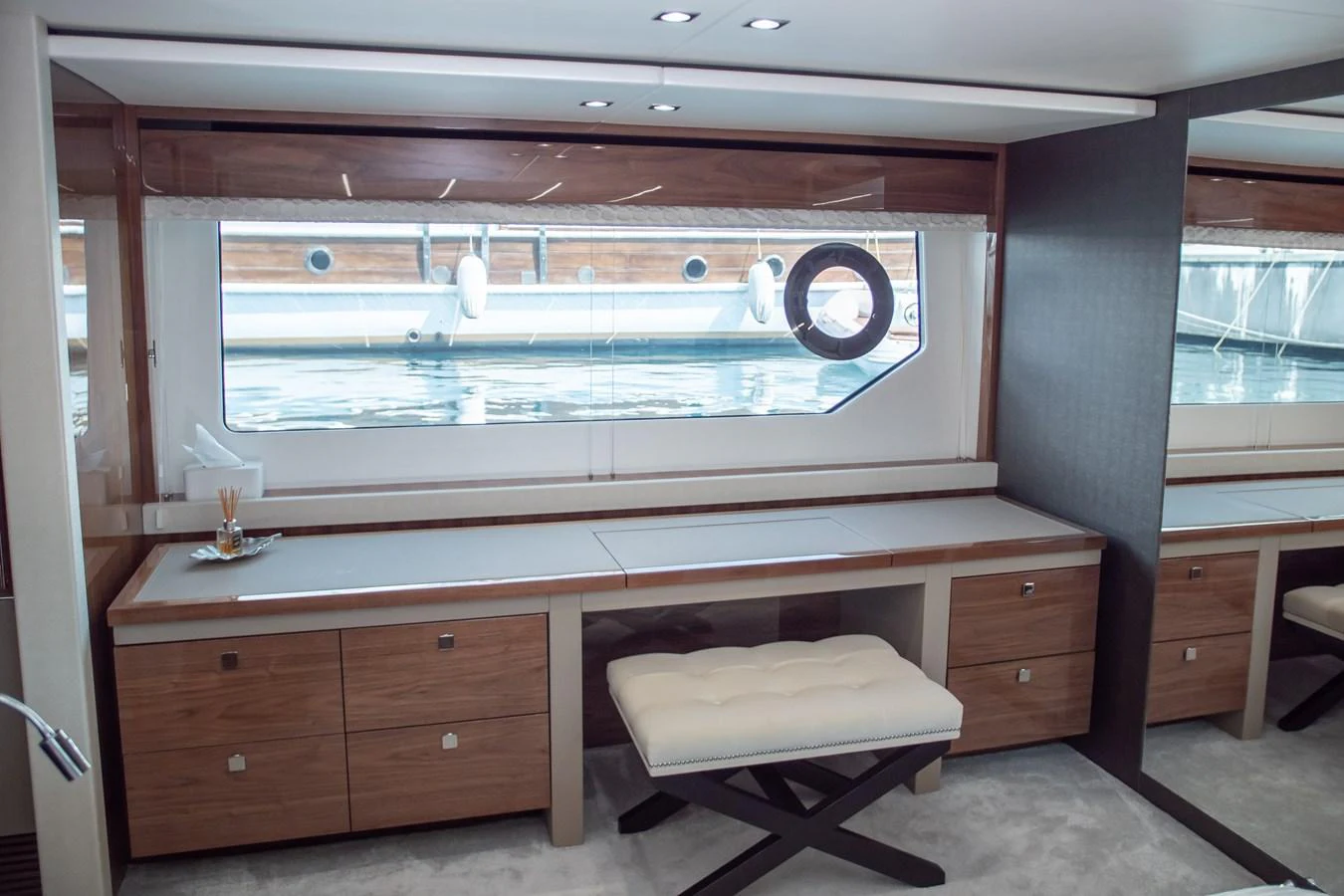 The yacht's interior features a sleek and modern workspace with a large window offering a view of the water. aboard SUNSEEKER 76Y Yacht for Sale