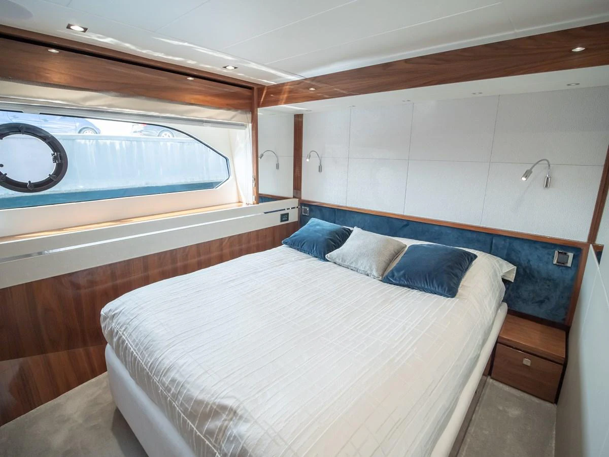 A luxurious stateroom featuring a large bed with plush pillows and elegant wood finishes. aboard SUNSEEKER 76Y Yacht for Sale