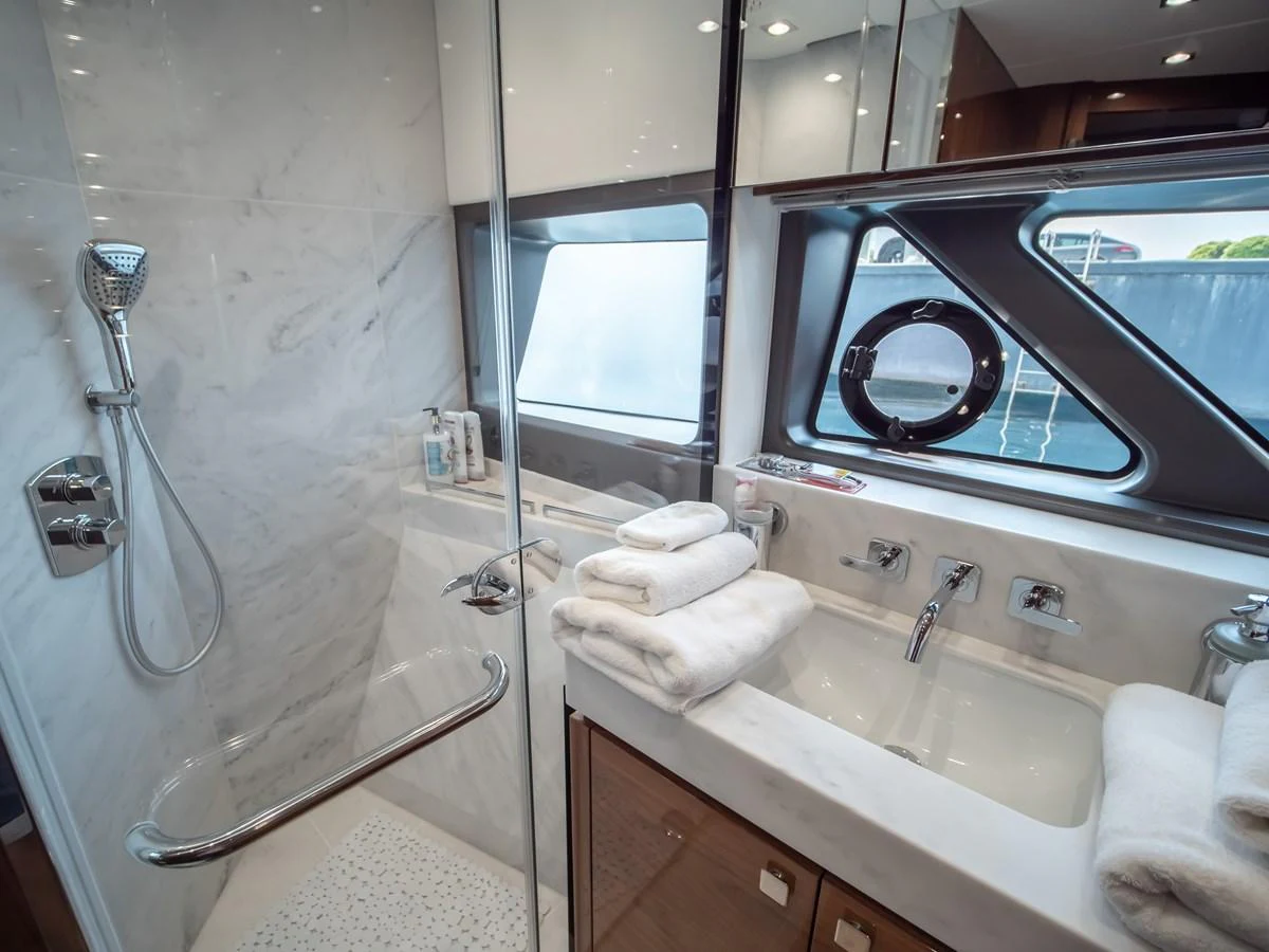 The yacht's bathroom features a sleek design with a glass-enclosed shower and modern fixtures. aboard SUNSEEKER 76Y Yacht for Sale