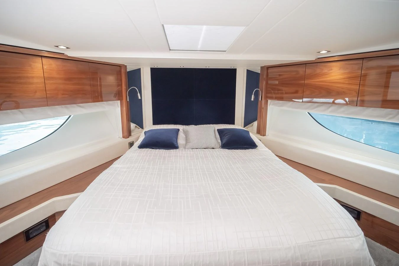 The stateroom features a spacious bed with elegant wood accents and large windows for natural light. aboard SUNSEEKER 76Y Yacht for Sale