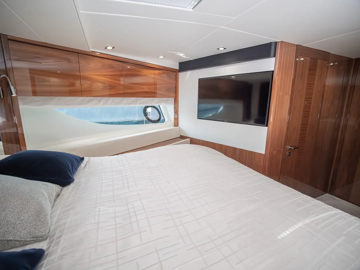 This elegant stateroom features a comfortable bed, sleek wood finishes, and a large flat-screen TV. aboard SUNSEEKER 76Y Yacht for Sale
