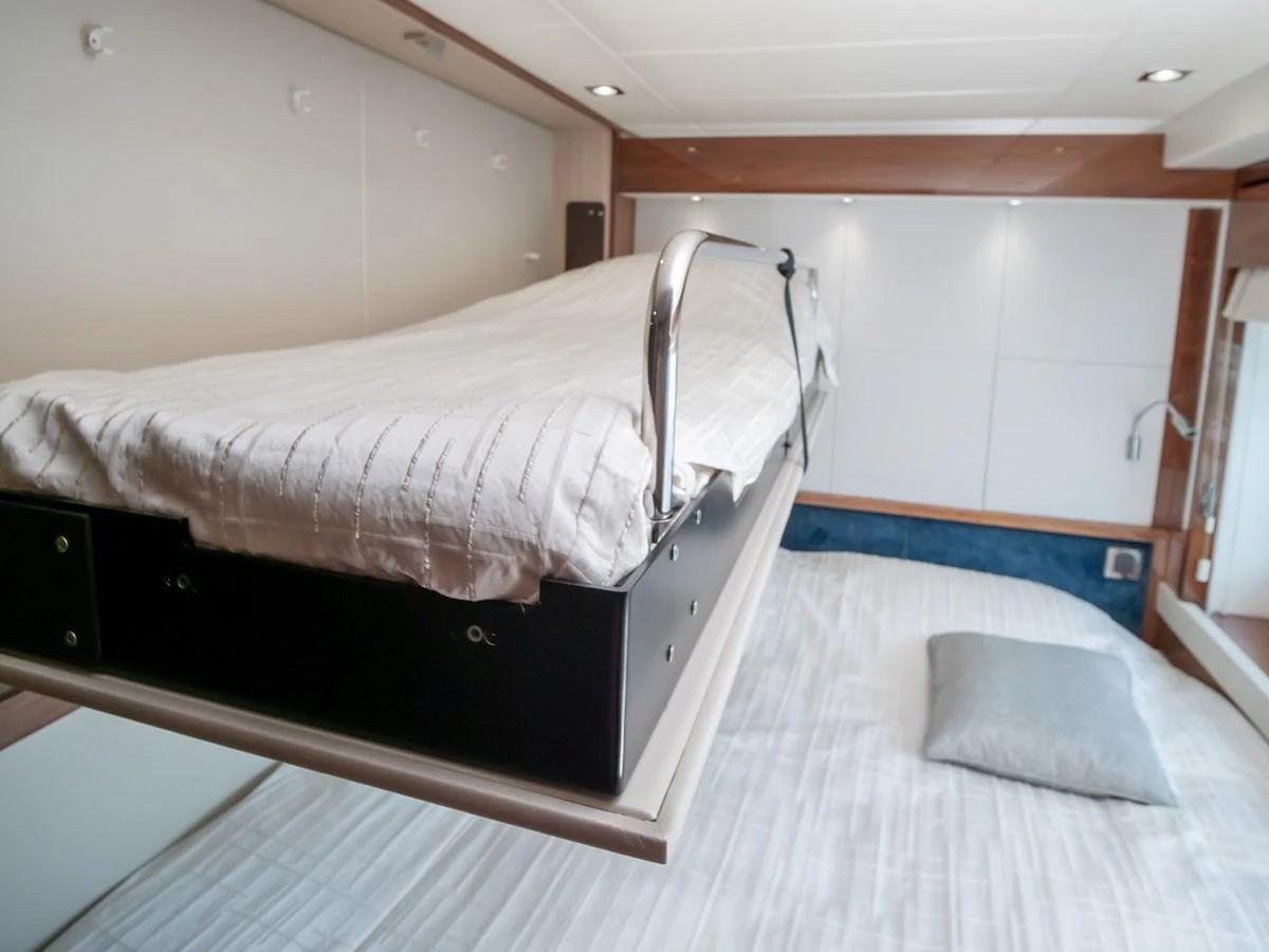 This image showcases a stateroom with a unique fold-down bunk bed above a larger bed, offering versatile sleeping arrangements. aboard SUNSEEKER 76Y Yacht for Sale