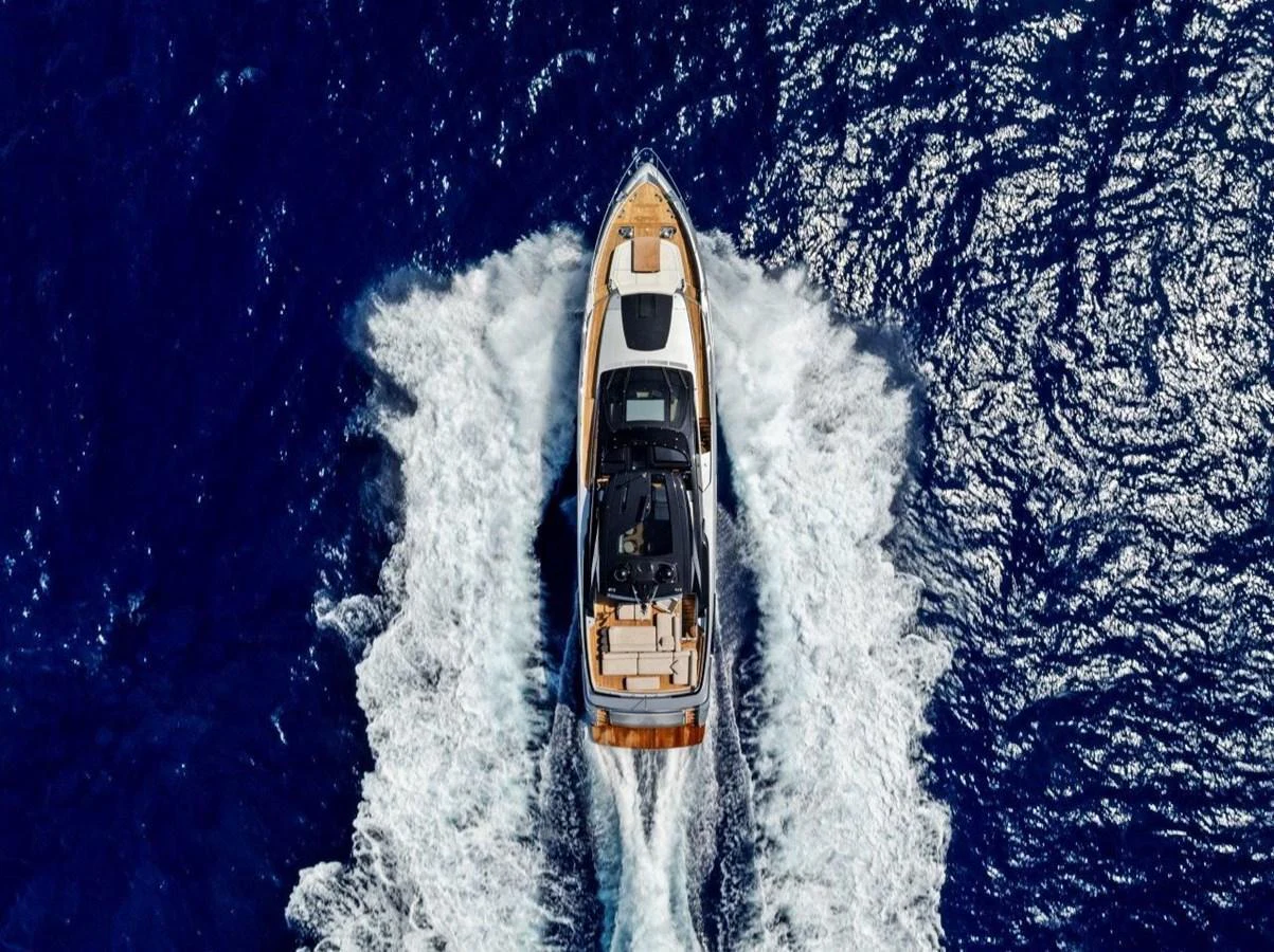 A stunning aerial view of a yacht cruising through deep blue waters, leaving a trail of white foam. aboard MSEA Yacht for Sale