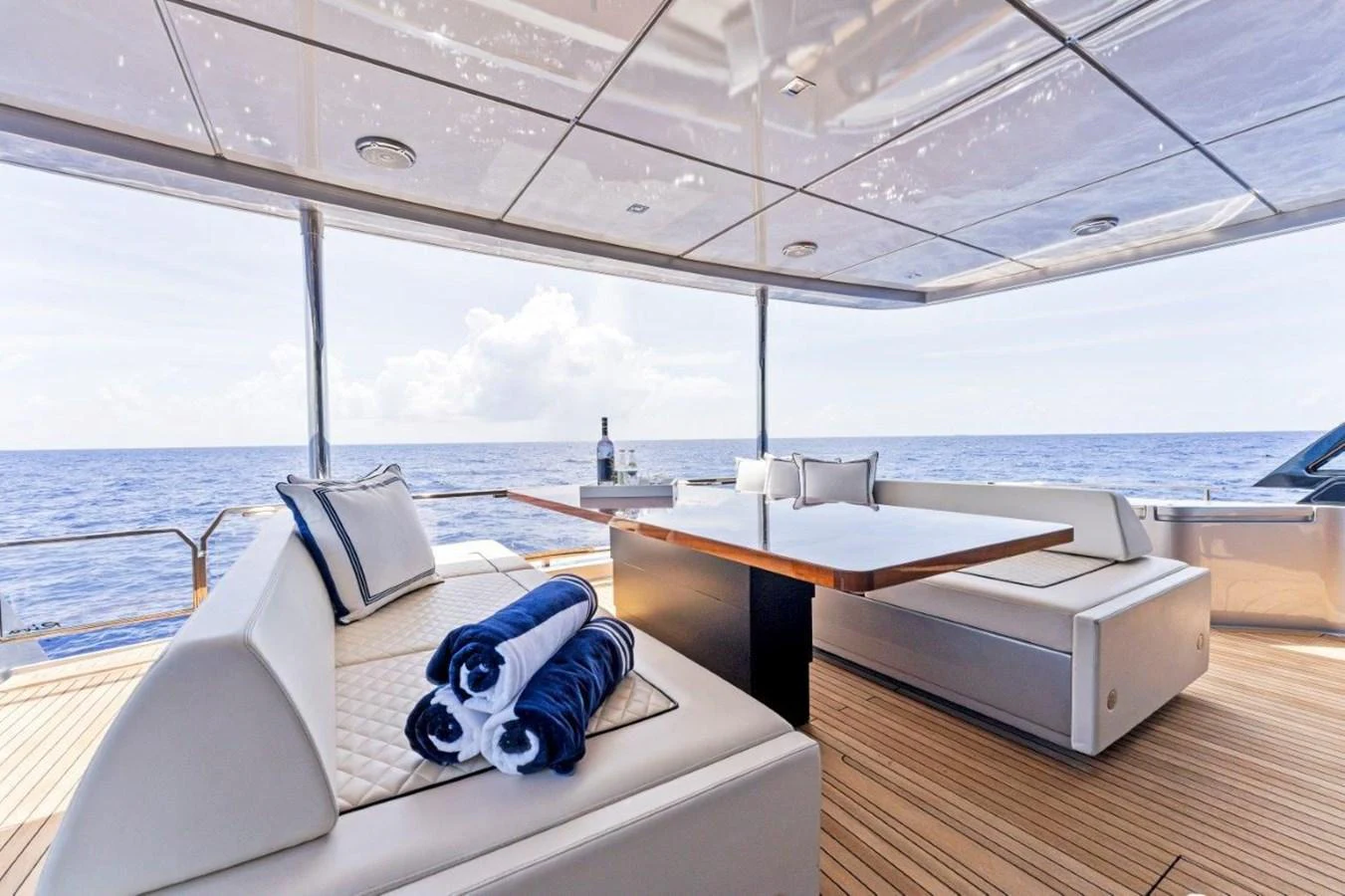 The aft deck offers a luxurious seating area with plush cushions and a dining table, perfect for enjoying the ocean views. aboard MSEA Yacht for Sale