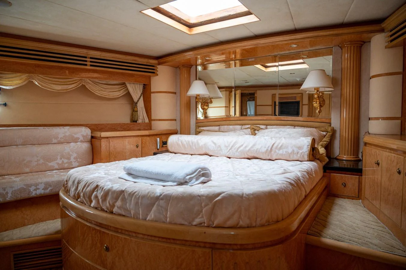 The master stateroom features a plush bed with elegant wood finishes and ample natural light. aboard LADY EILEEN Yacht for Sale