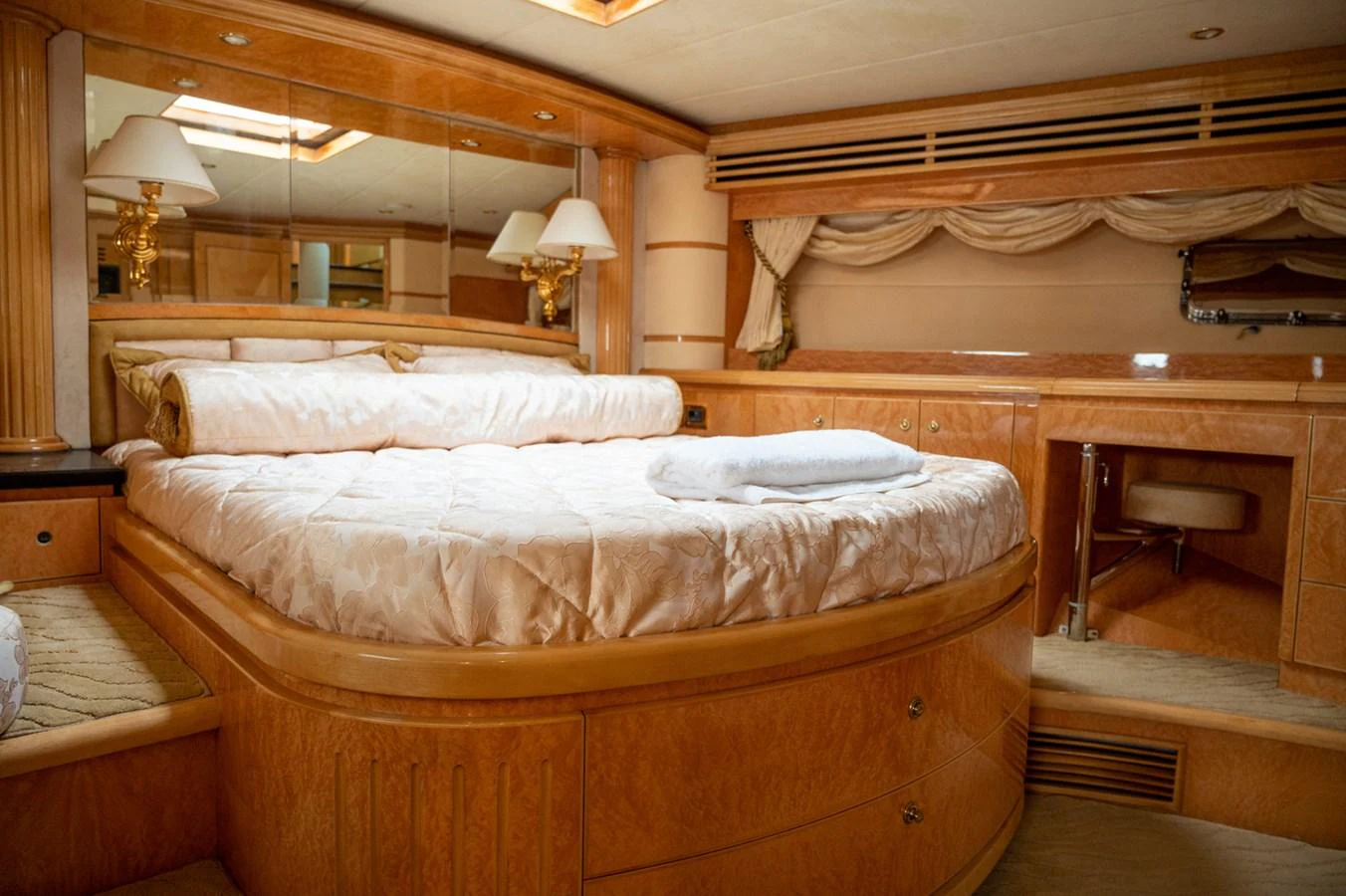 The master stateroom features a luxurious bed with elegant wood finishes and ample natural light. aboard LADY EILEEN Yacht for Sale