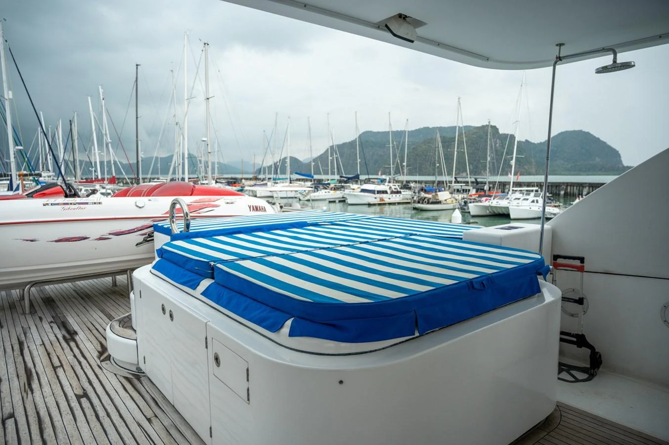 The aft deck features a spacious sunpad with a striped cover, perfect for relaxation. aboard LADY EILEEN Yacht for Sale