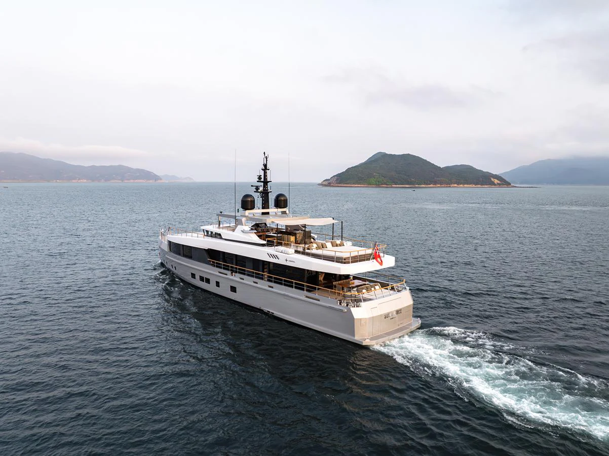 A sleek and modern yacht cruises through calm waters with scenic islands in the background. aboard SUN PRINCE Yacht for Sale
