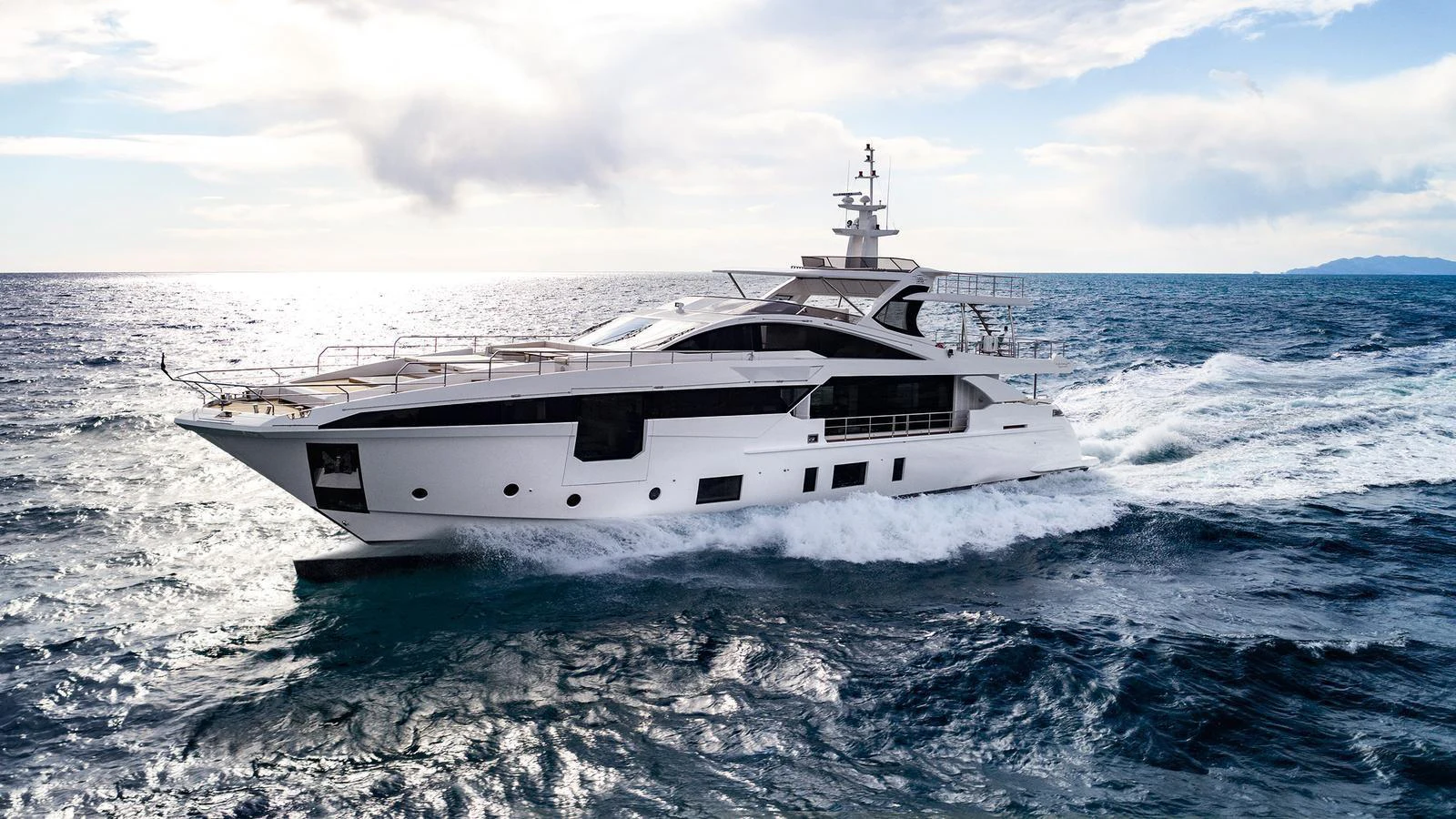 A sleek and modern yacht cruises through the open sea under a bright sky. aboard PANTERA Yacht for Sale