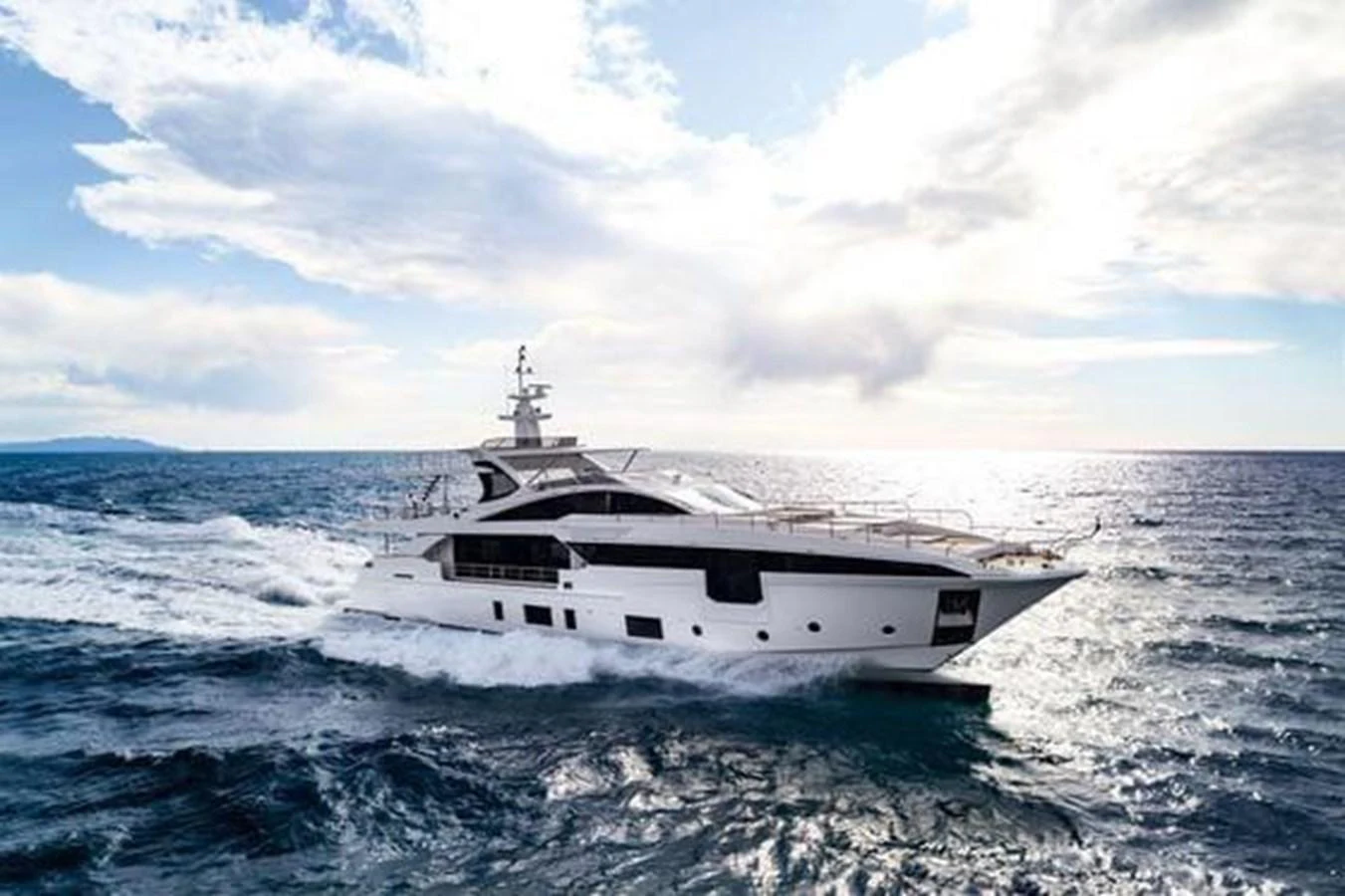 A sleek yacht cruises through the open sea under a partly cloudy sky. aboard PANTERA Yacht for Sale