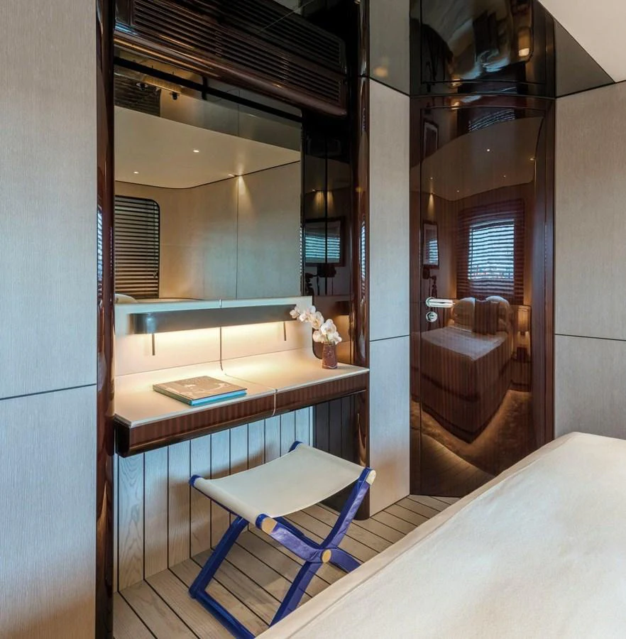 A luxurious stateroom featuring a sleek vanity area with a modern stool and elegant lighting. aboard PANTERA Yacht for Sale