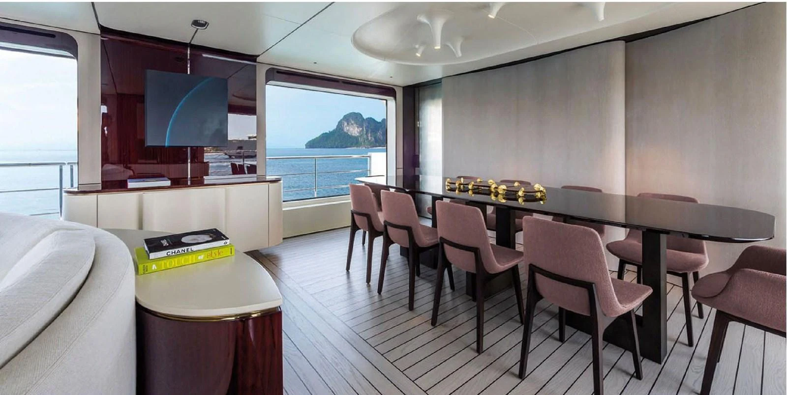 The yacht's dining area features a sleek table with modern chairs, set against large windows offering stunning ocean views. aboard PANTERA Yacht for Sale