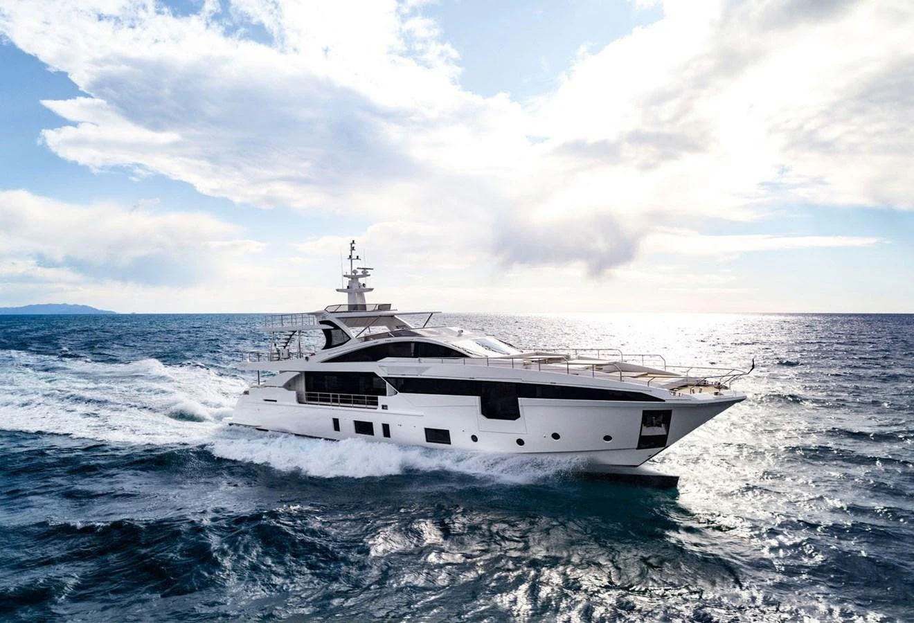 A sleek and modern yacht cruises through the open sea under a partly cloudy sky. aboard PANTERA Yacht for Sale