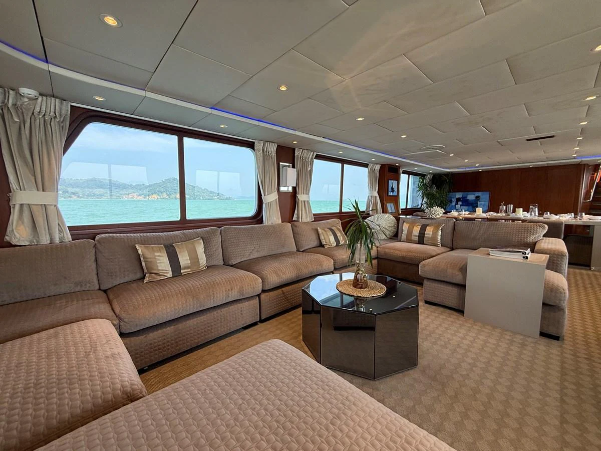 The spacious salon features plush seating and panoramic windows offering stunning ocean views. aboard LIGAYA Yacht for Sale