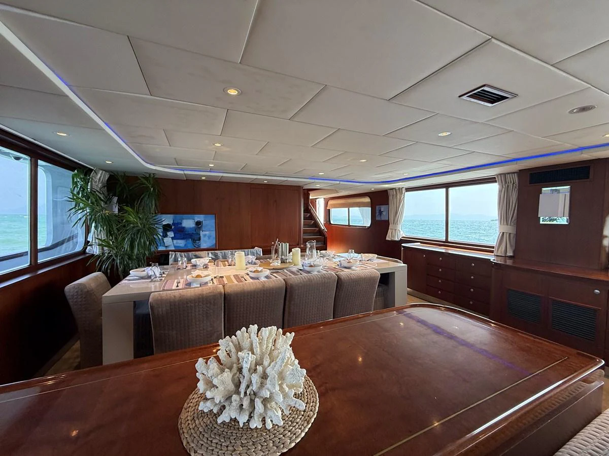 The yacht's dining area features a beautifully set table with panoramic ocean views. aboard LIGAYA Yacht for Sale