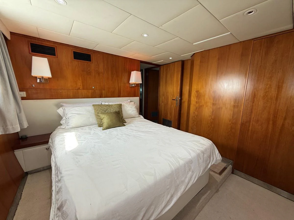 A cozy stateroom with warm wood paneling and a comfortable bed. aboard LIGAYA Yacht for Sale