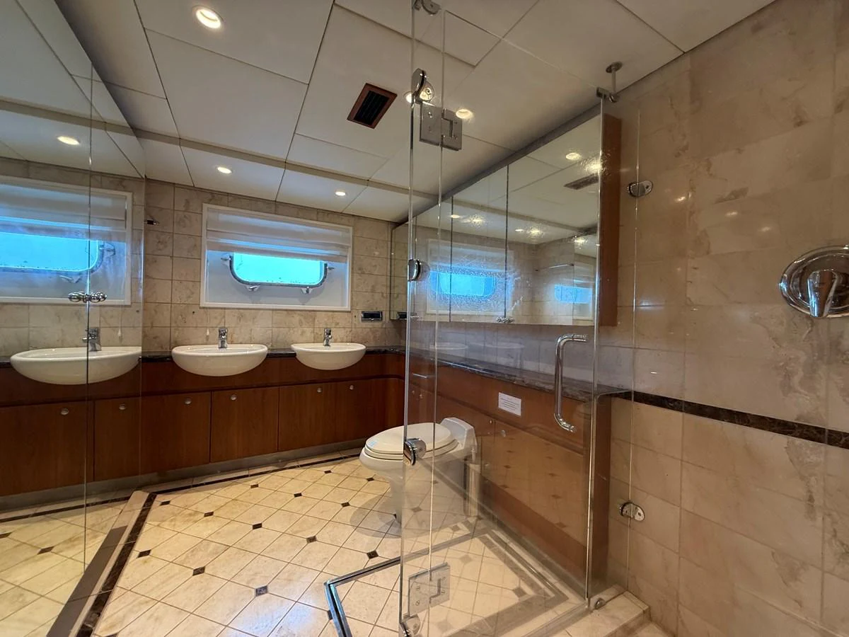 The yacht's bathroom features a spacious and elegant design with dual sinks and a glass-enclosed shower. aboard LIGAYA Yacht for Sale