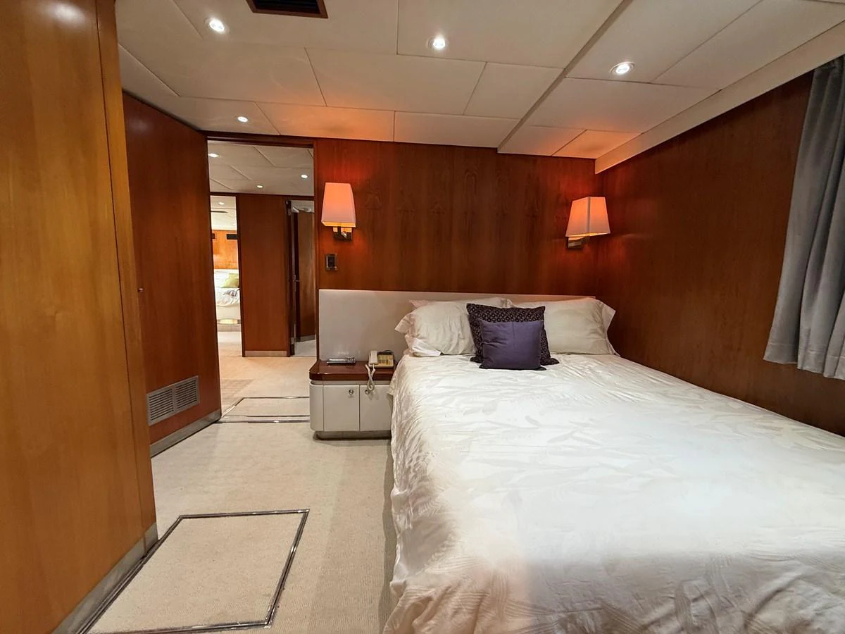 A cozy stateroom featuring a comfortable bed with elegant lighting and wooden paneling. aboard LIGAYA Yacht for Sale