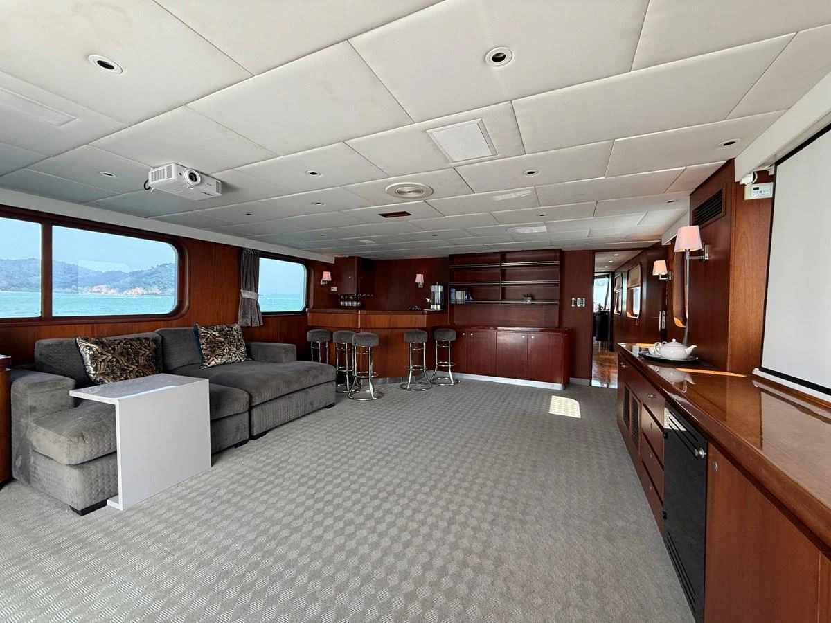 The spacious salon features comfortable seating, a bar area, and large windows offering scenic views. aboard LIGAYA Yacht for Sale