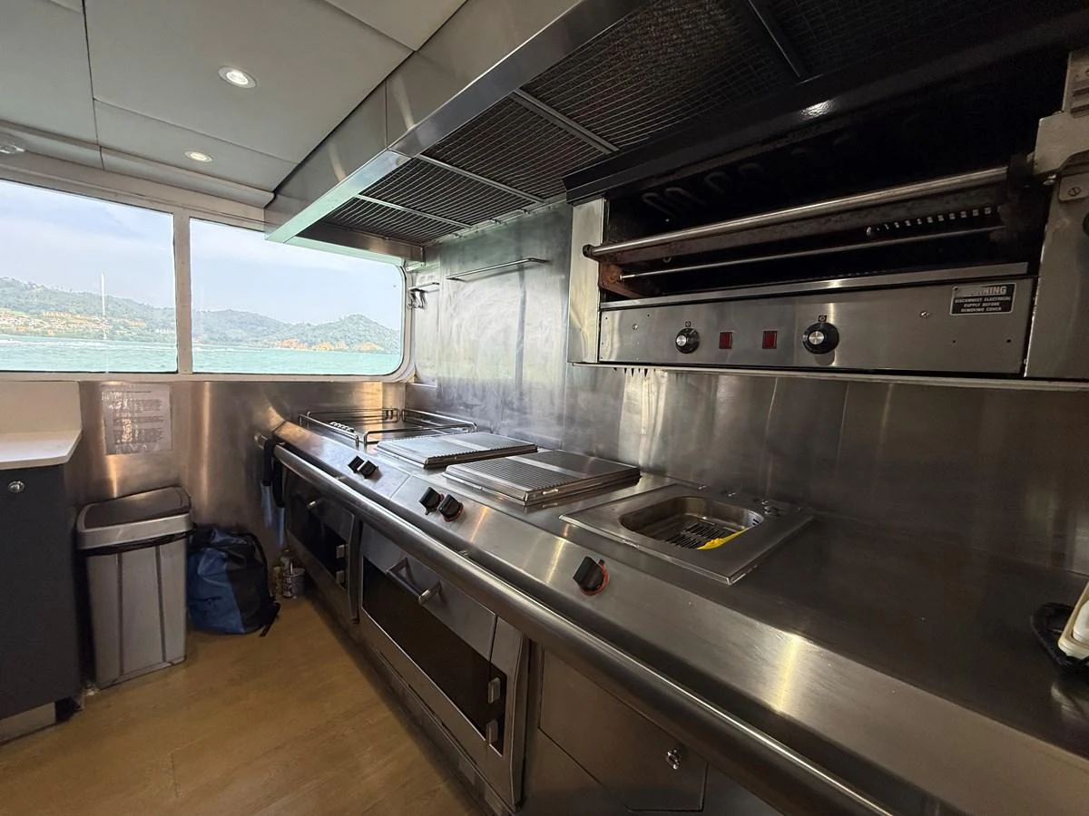 The yacht's galley features professional-grade stainless steel appliances and ample counter space with a scenic view through the window. aboard LIGAYA Yacht for Sale