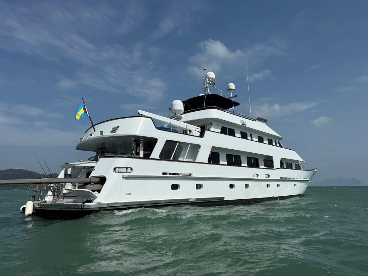 A luxurious yacht glides through the water under a clear blue sky. aboard LIGAYA Yacht for Sale