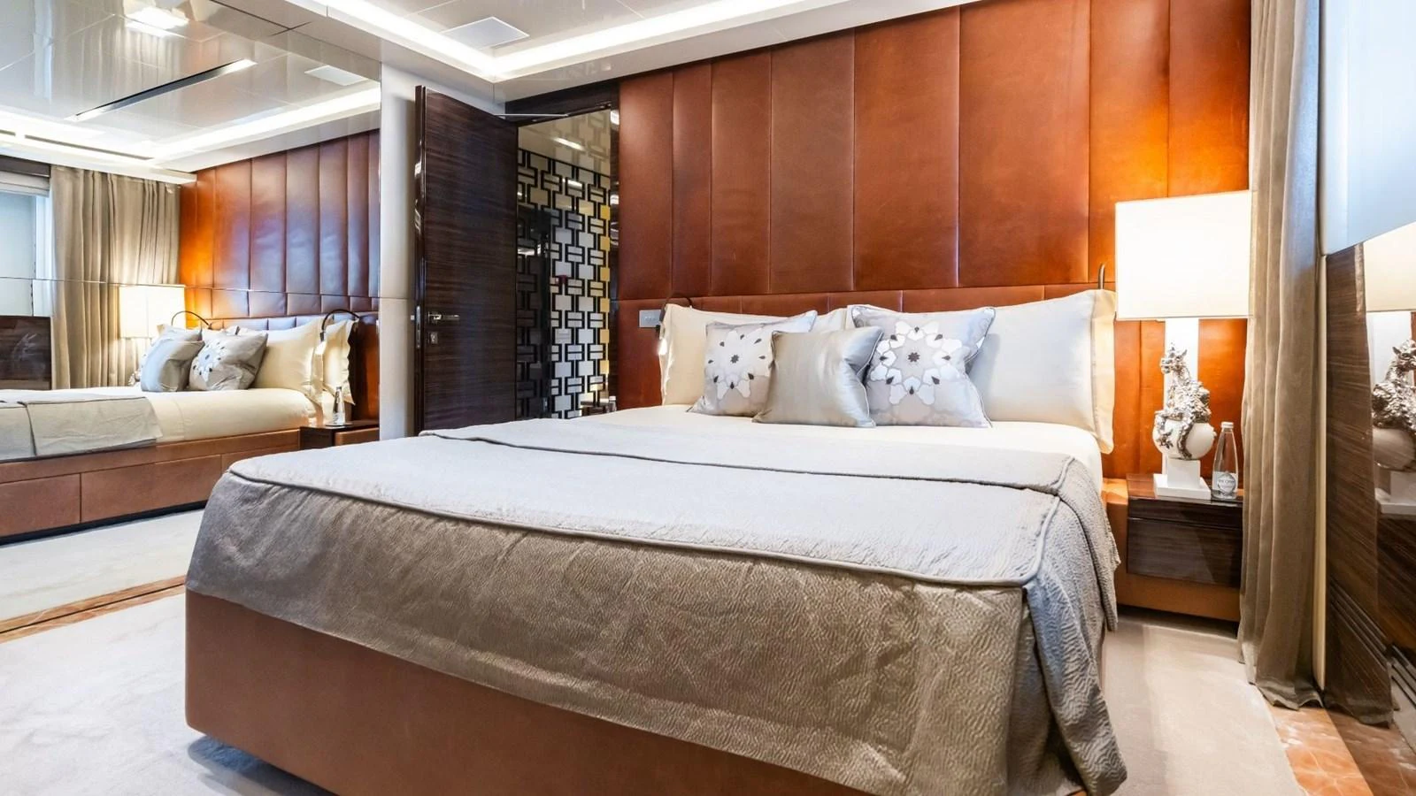 The master stateroom features a luxurious bed with elegant decor and warm lighting. aboard BLUE MOON Yacht for Sale