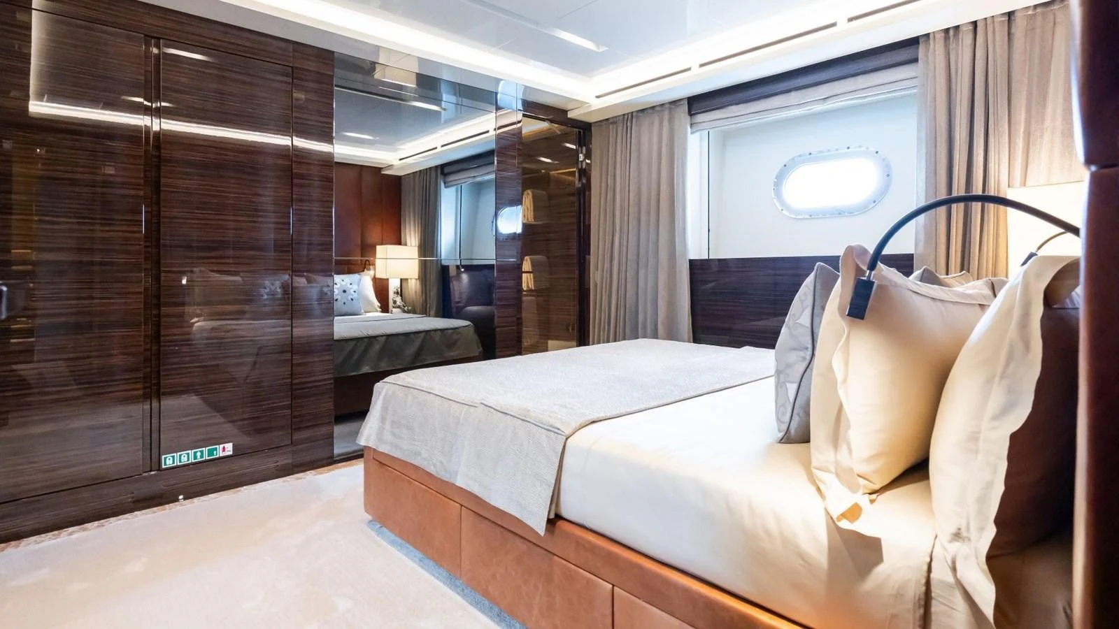 The stateroom features luxurious bedding and elegant wood paneling, creating a serene and sophisticated atmosphere. aboard BLUE MOON Yacht for Sale