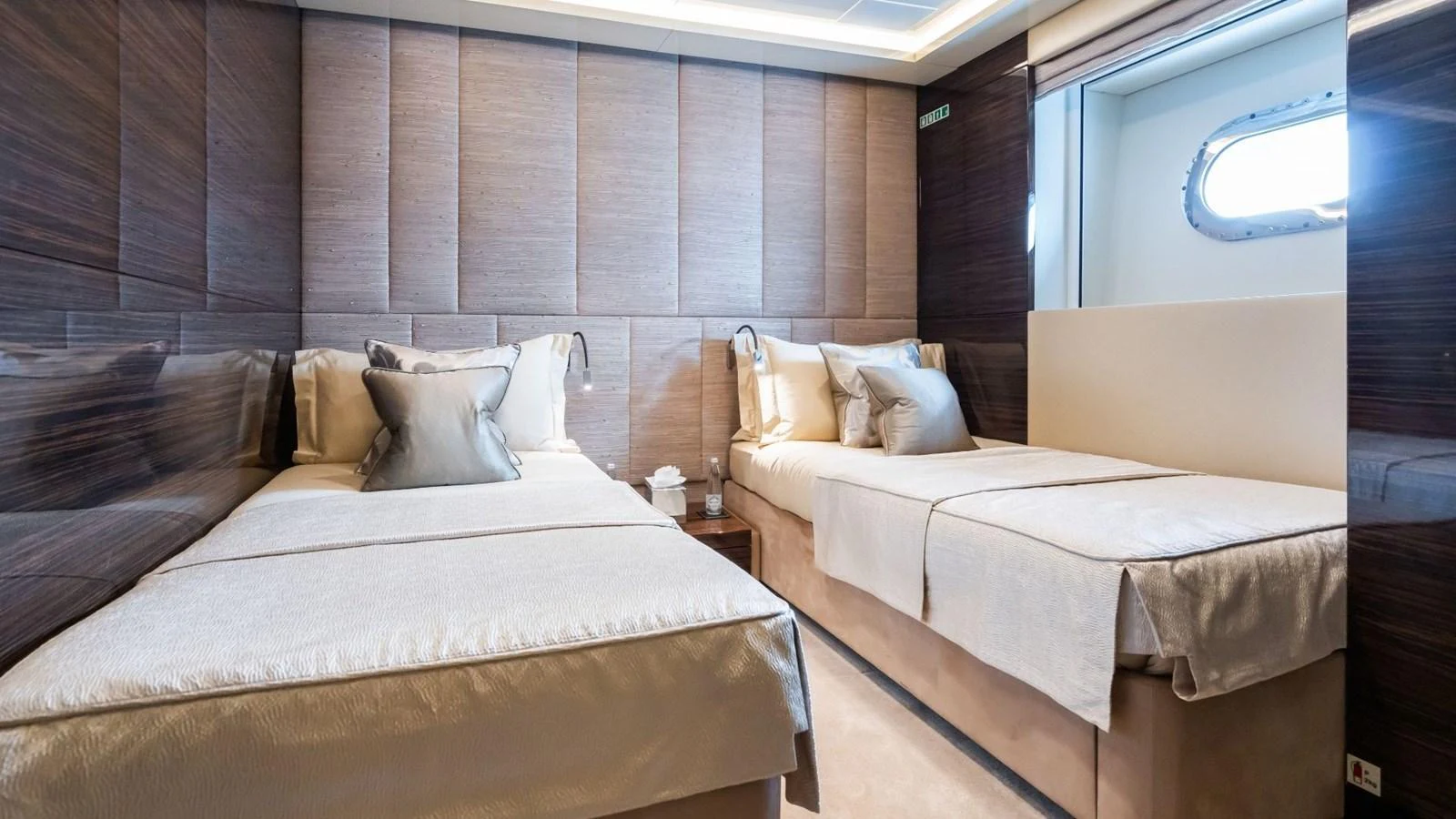 The guest stateroom features twin beds with elegant bedding and a modern, sophisticated design. aboard BLUE MOON Yacht for Sale