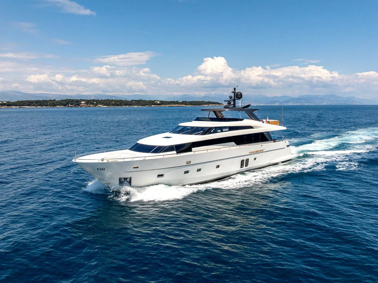 A sleek and modern yacht cruising through clear blue waters under a bright sky. aboard CALM Yacht for Sale