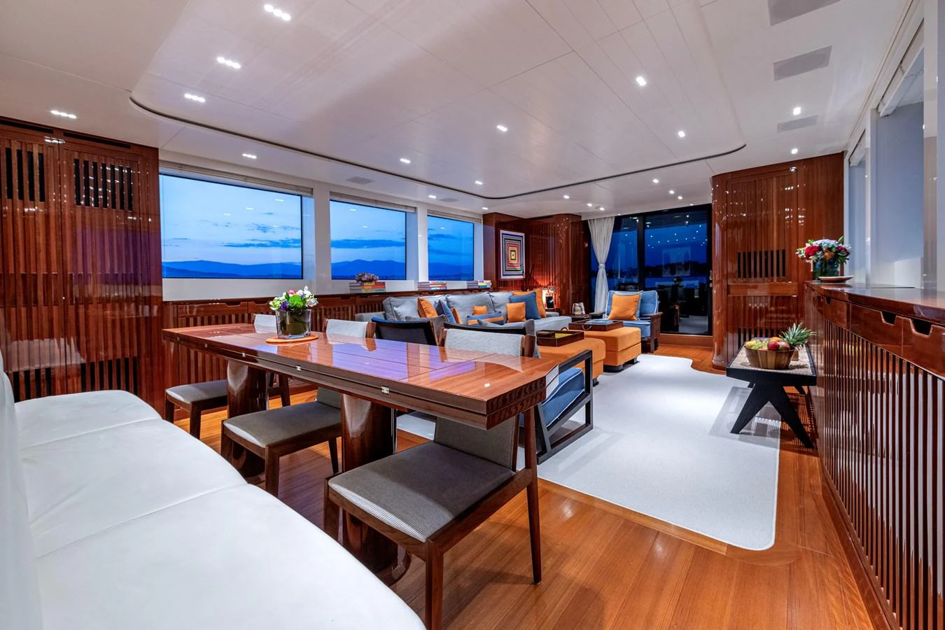 The salon features elegant wood finishes, plush seating, and expansive windows offering stunning views. aboard CALM Yacht for Sale