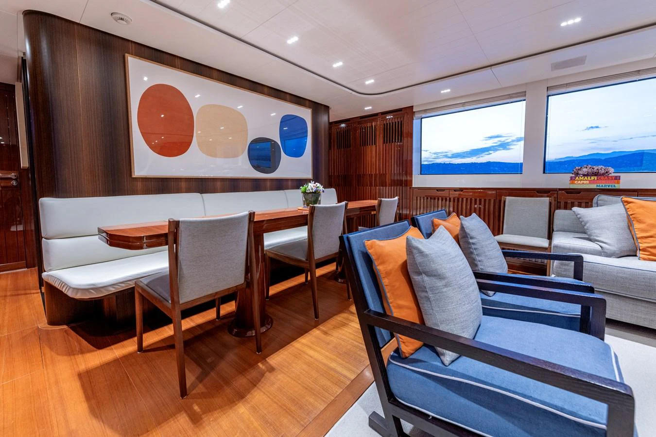 The salon features a stylish and comfortable seating area with modern decor and large windows offering scenic views. aboard CALM Yacht for Sale
