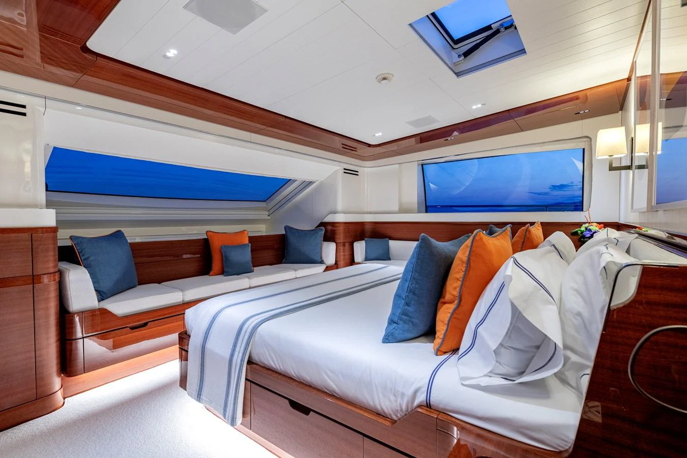 The master stateroom features a luxurious bed with elegant linens, ample seating, and large windows offering stunning views. aboard CALM Yacht for Sale