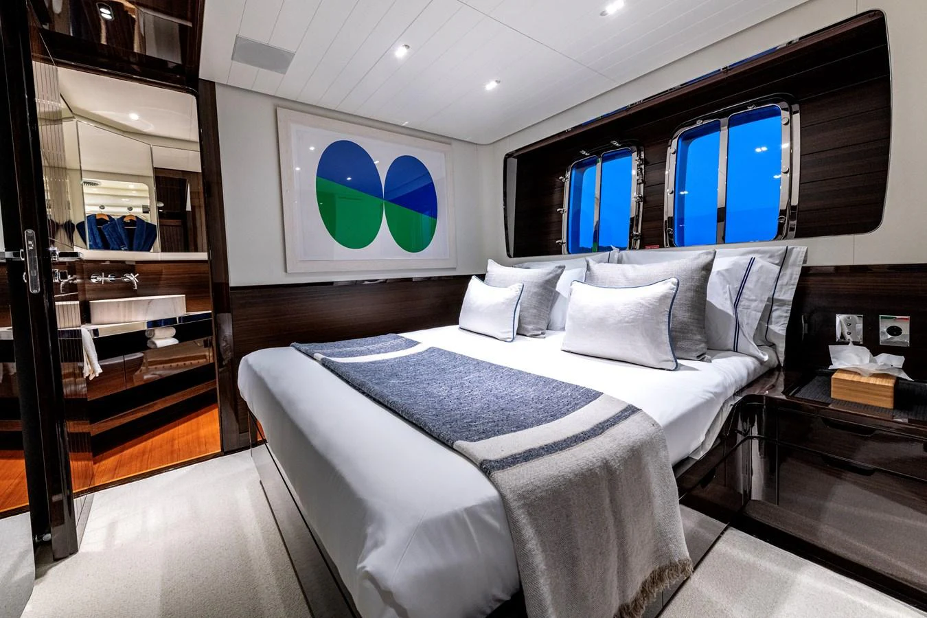 The stateroom features a luxurious bed with elegant linens and modern decor. aboard CALM Yacht for Sale