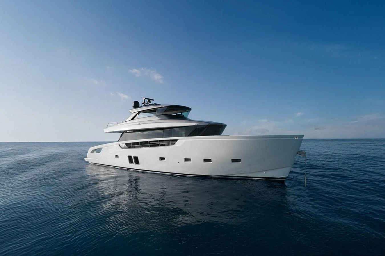 A sleek and modern yacht cruising on calm waters under a clear blue sky. aboard SANLORENZO SX 76 KYOMU Yacht for Sale