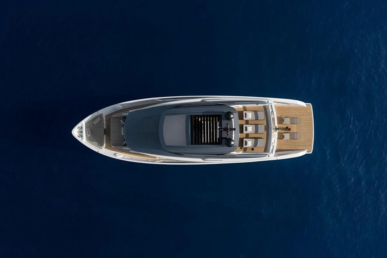 A sleek yacht is captured from an aerial view, showcasing its elegant design and spacious deck areas. aboard SANLORENZO SX 76 KYOMU Yacht for Sale