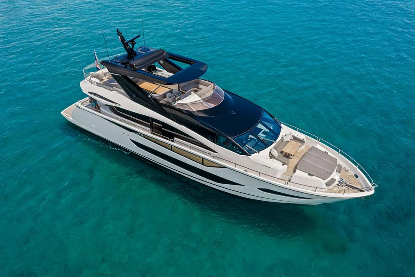 A sleek and modern yacht glides gracefully on clear blue waters. aboard DOLCE FAR NIENTE Yacht for Sale