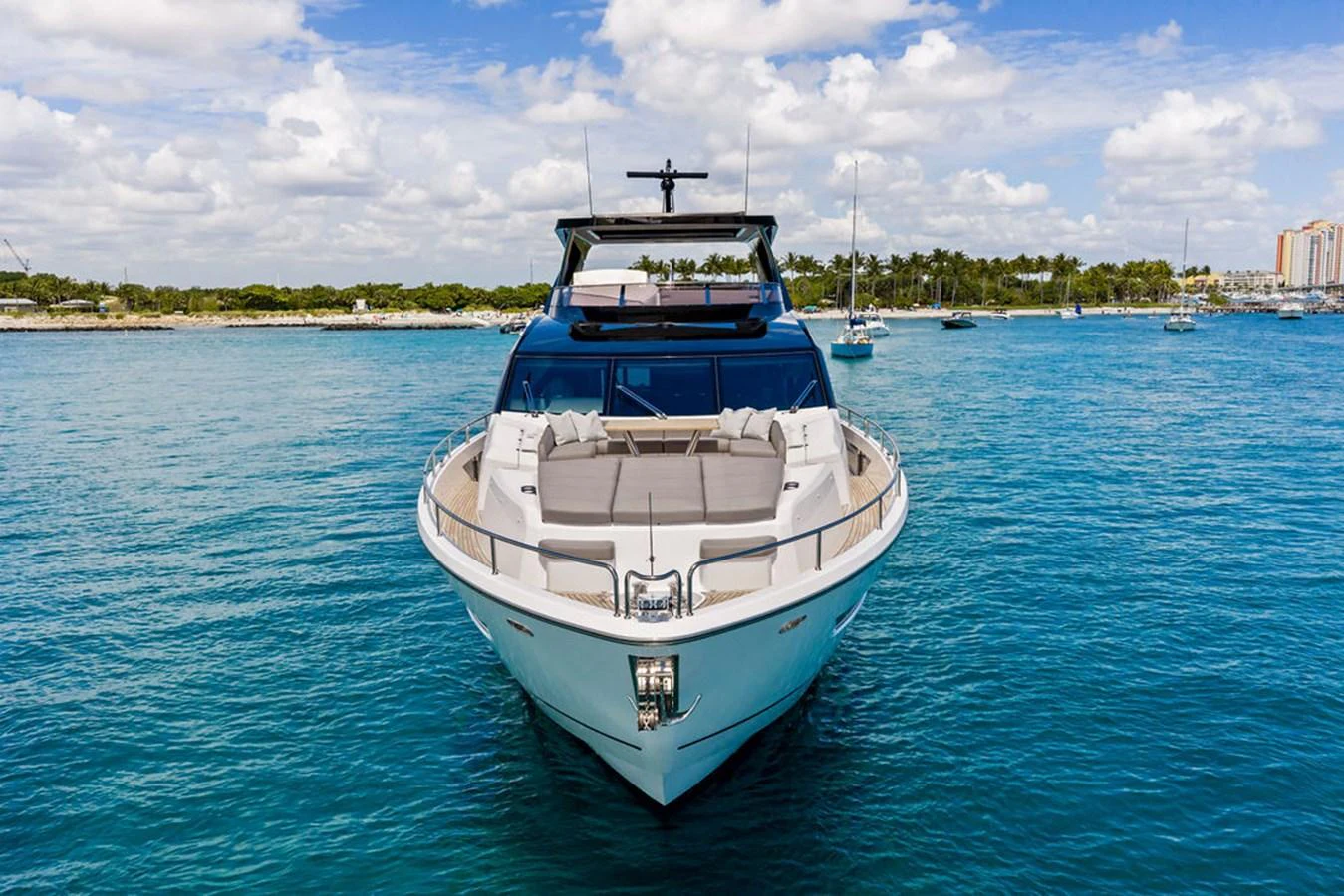 A sleek yacht is anchored in calm blue waters under a partly cloudy sky. aboard DOLCE FAR NIENTE Yacht for Sale