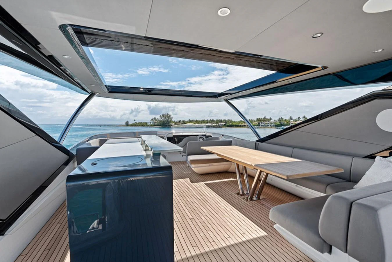 The spacious sundeck features modern seating and a large dining table under a retractable roof. aboard DOLCE FAR NIENTE Yacht for Sale
