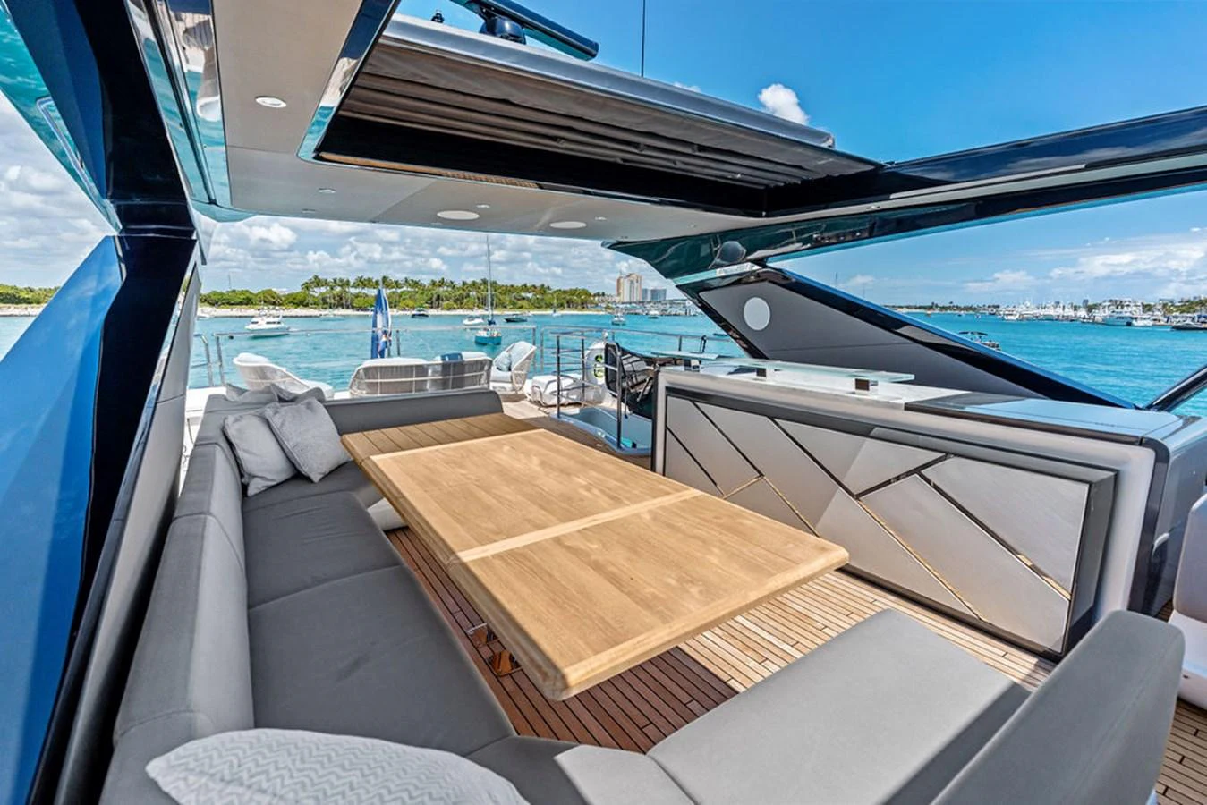 The aft deck features a spacious seating area with a large wooden table, perfect for alfresco dining. aboard DOLCE FAR NIENTE Yacht for Sale