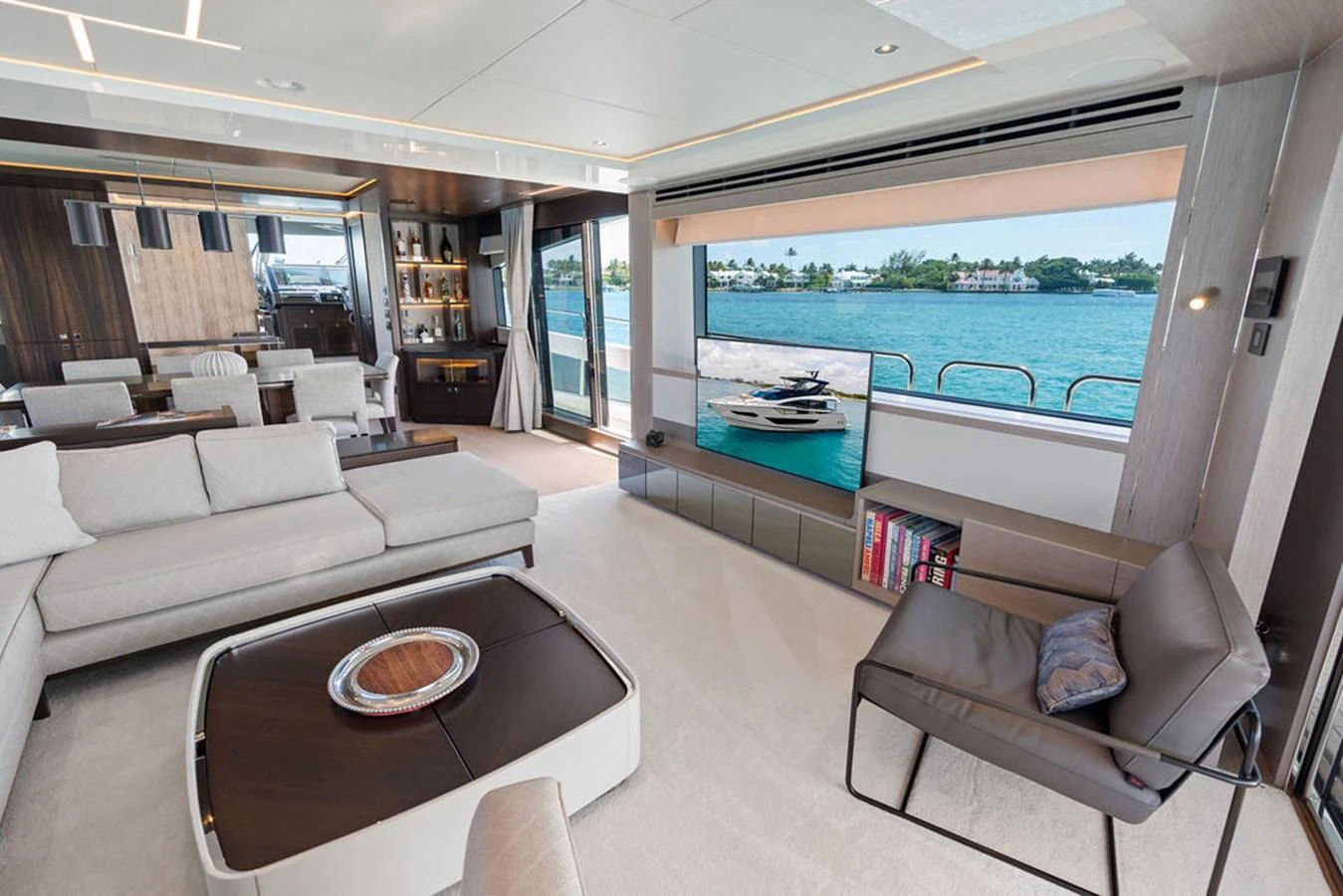 The salon offers a spacious and luxurious living area with large windows providing stunning views of the water. aboard DOLCE FAR NIENTE Yacht for Sale
