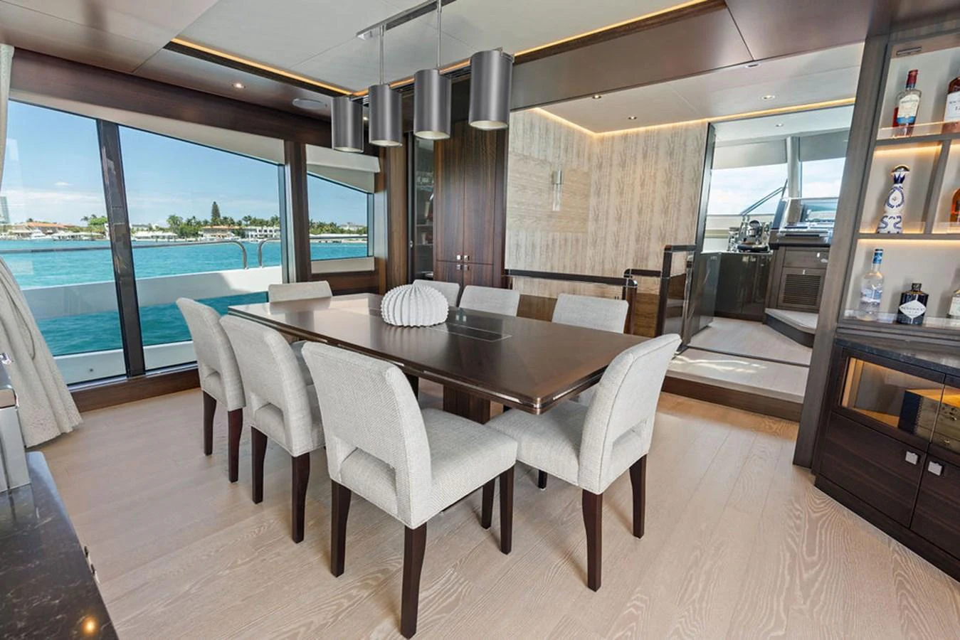 The yacht's dining area features a sleek table with comfortable seating and large windows offering stunning views. aboard DOLCE FAR NIENTE Yacht for Sale