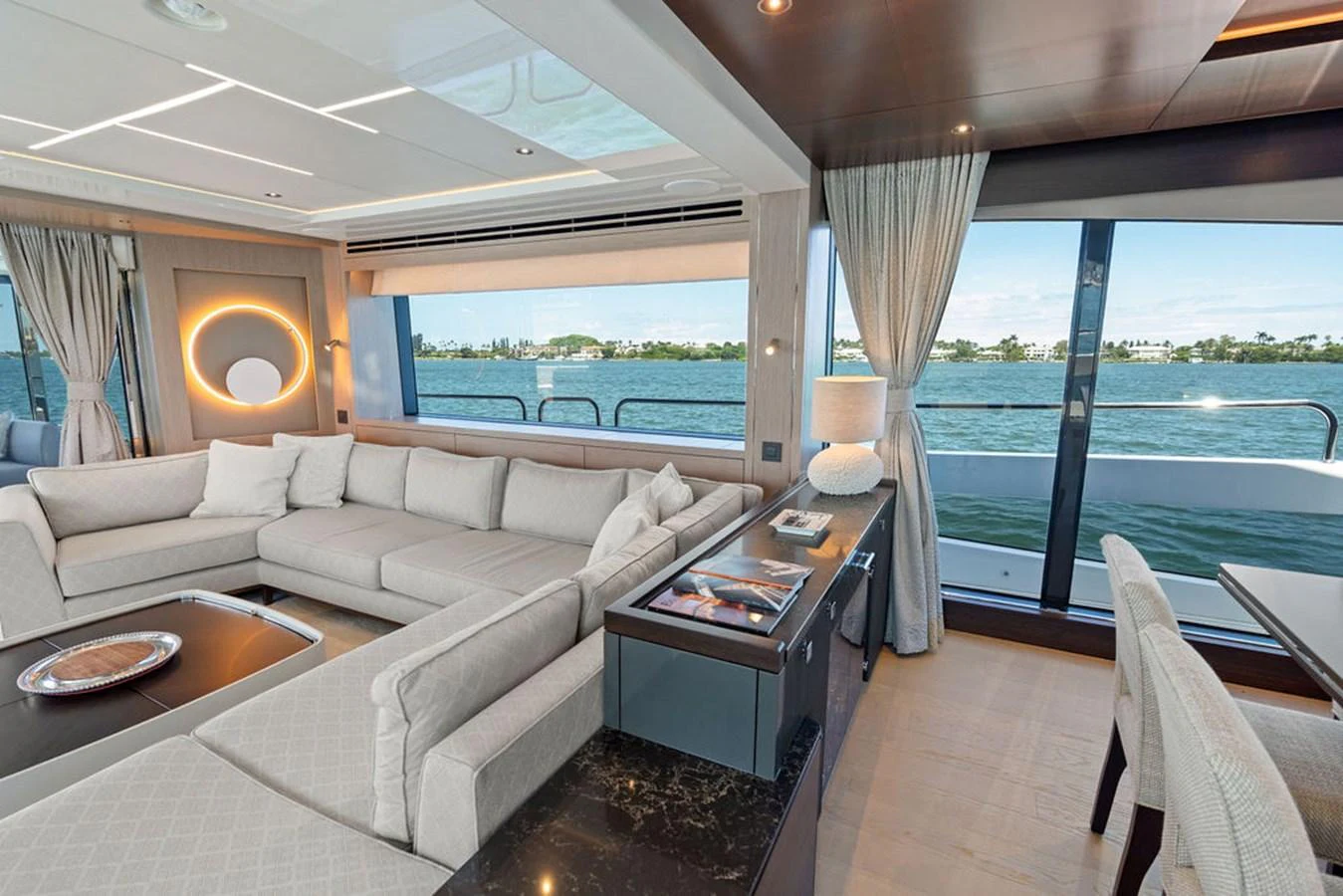 The salon offers a spacious and elegant seating area with large windows providing stunning views of the water. aboard DOLCE FAR NIENTE Yacht for Sale