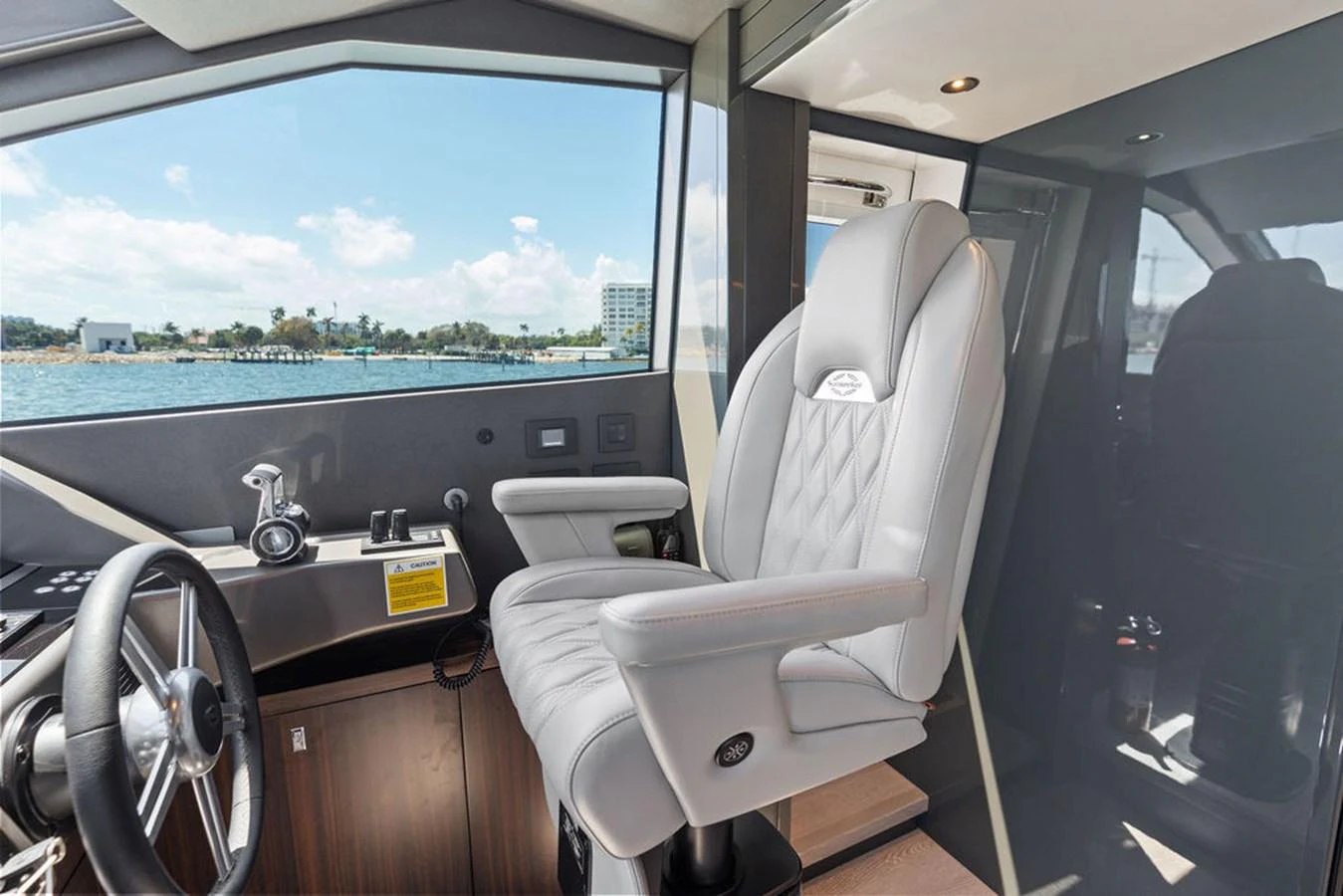 The helm station features a luxurious captain's chair with a view of the water through large windows. aboard DOLCE FAR NIENTE Yacht for Sale