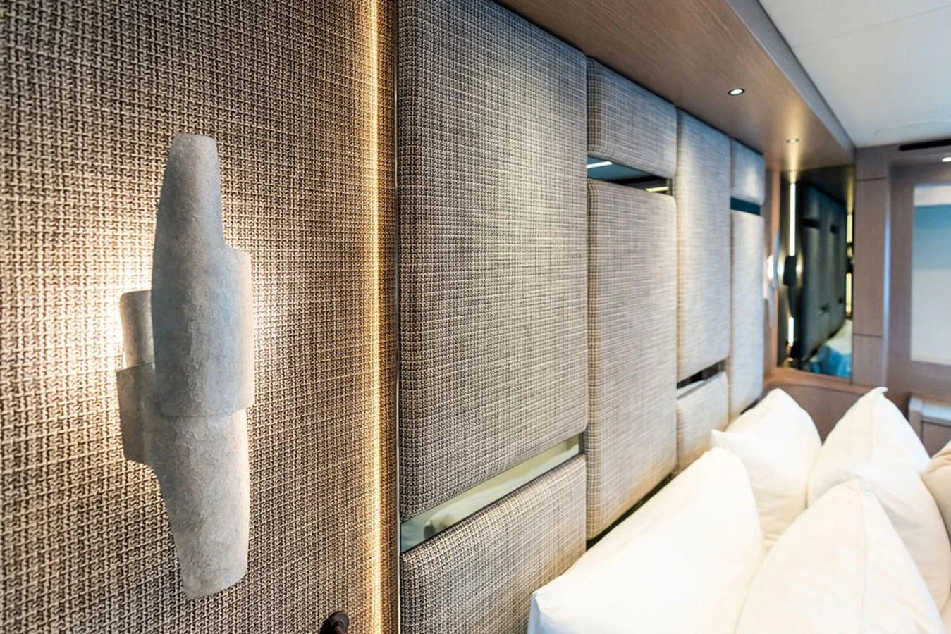 The image showcases a luxurious and modern interior wall with textured panels and soft lighting. aboard DOLCE FAR NIENTE Yacht for Sale