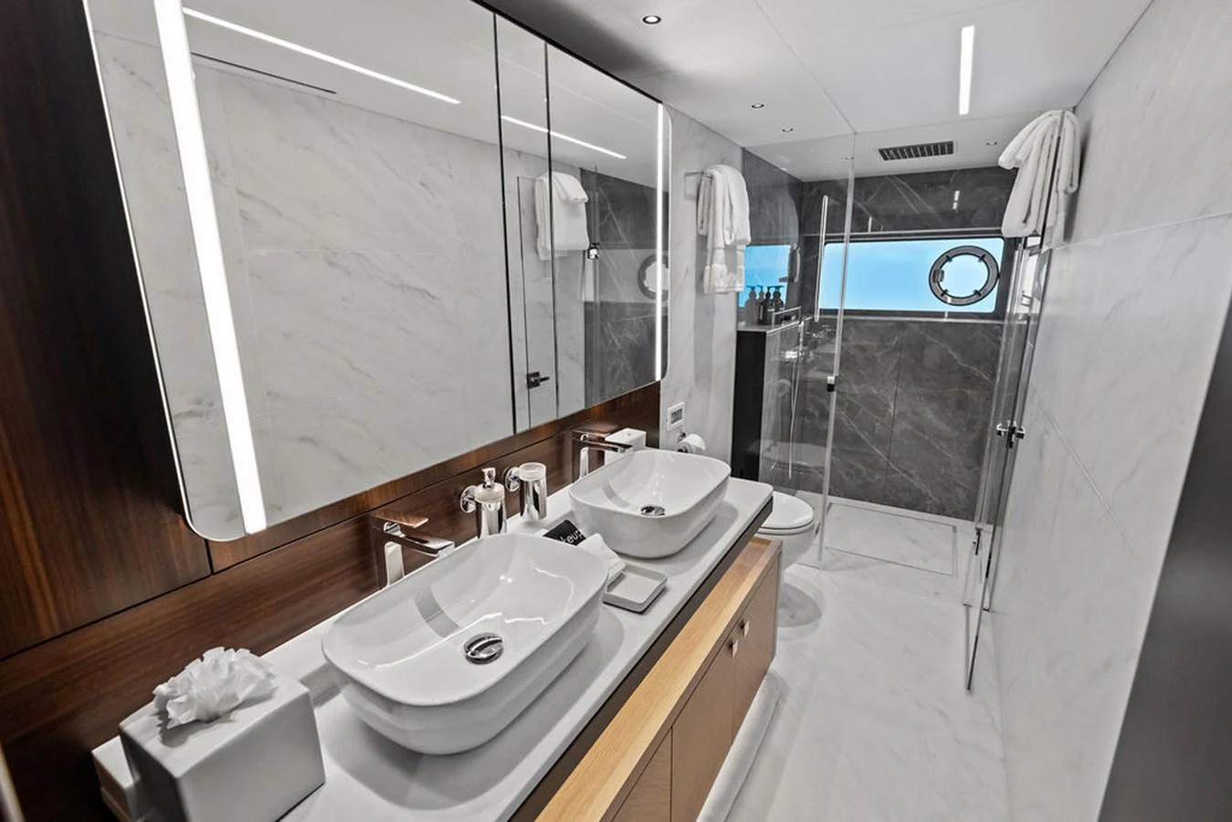 The yacht's bathroom features a sleek, modern design with dual sinks and a spacious shower area. aboard DOLCE FAR NIENTE Yacht for Sale