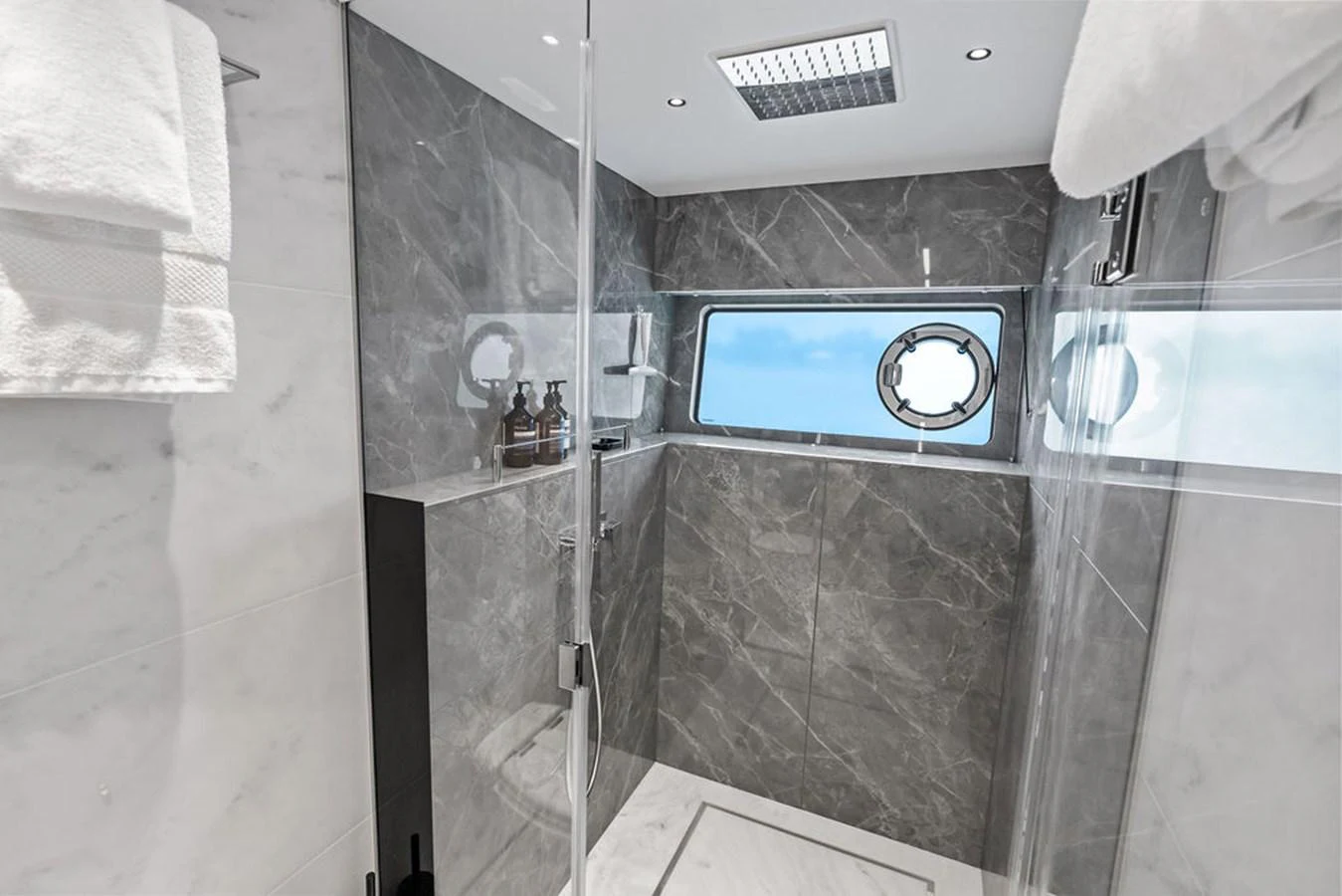 A luxurious yacht bathroom featuring a sleek shower area with a window view. aboard DOLCE FAR NIENTE Yacht for Sale