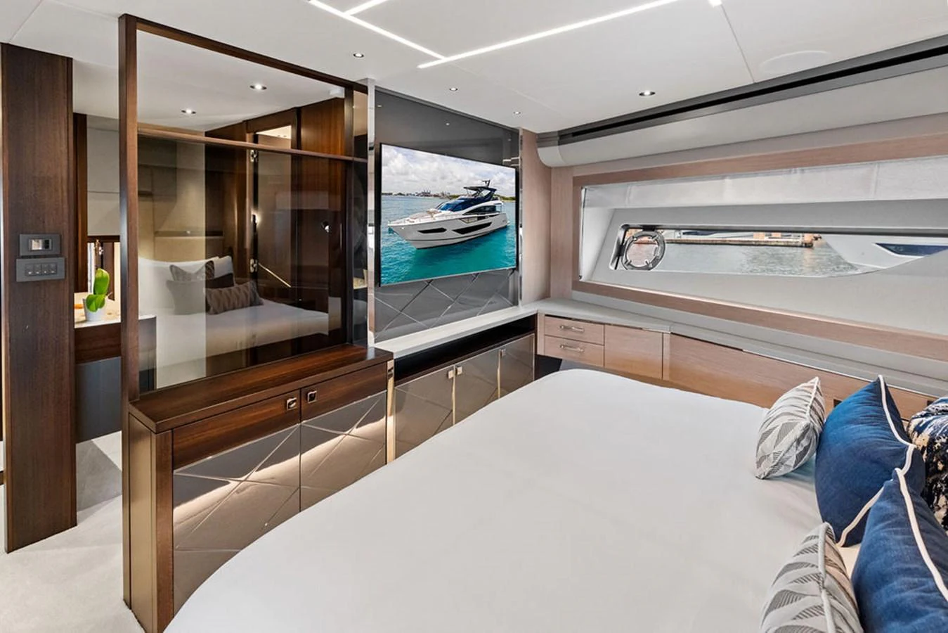 The luxurious stateroom features a large bed, elegant wood finishes, and a scenic window view. aboard DOLCE FAR NIENTE Yacht for Sale