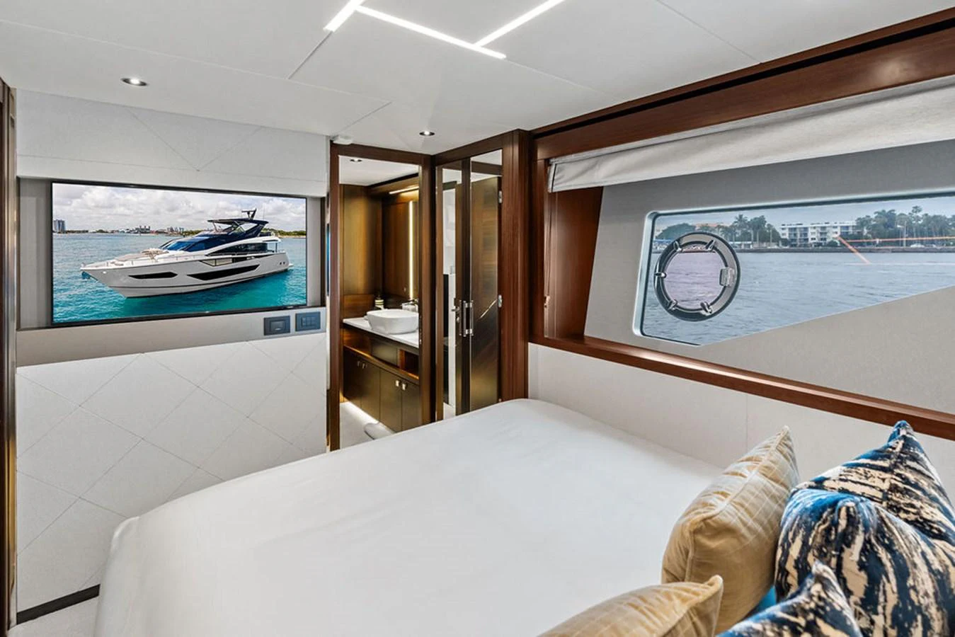 A luxurious stateroom with a large bed, modern decor, and a view of the sea through the window. aboard DOLCE FAR NIENTE Yacht for Sale