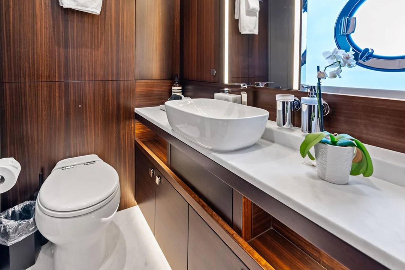 A luxurious yacht bathroom featuring elegant wood paneling and modern fixtures. aboard DOLCE FAR NIENTE Yacht for Sale