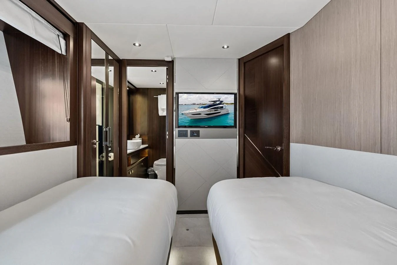 A modern guest cabin with twin beds and a view of the ensuite bathroom. aboard DOLCE FAR NIENTE Yacht for Sale